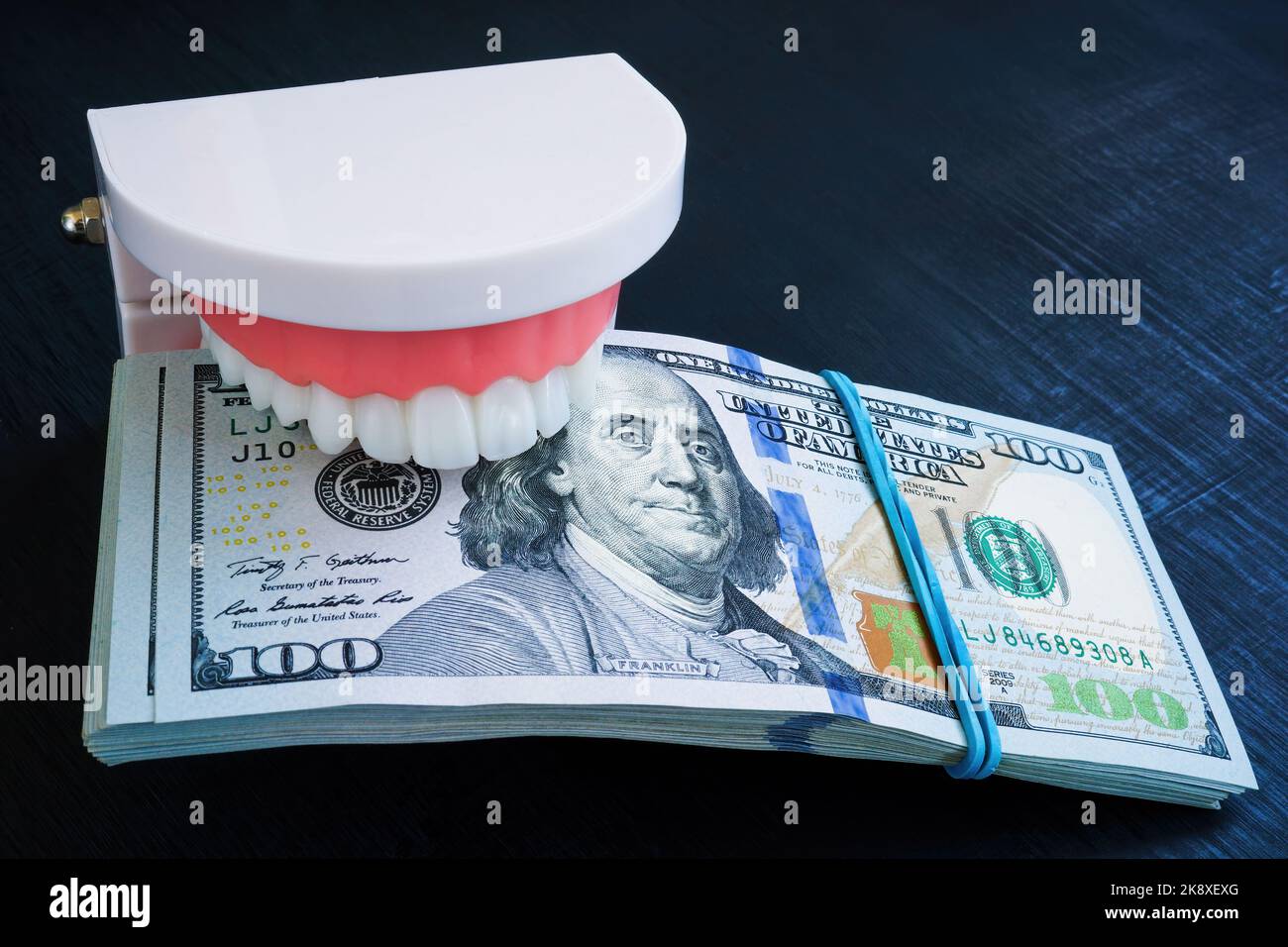 Jaws holding a stack of banknotes. Dental insurance concept. Stock Photo