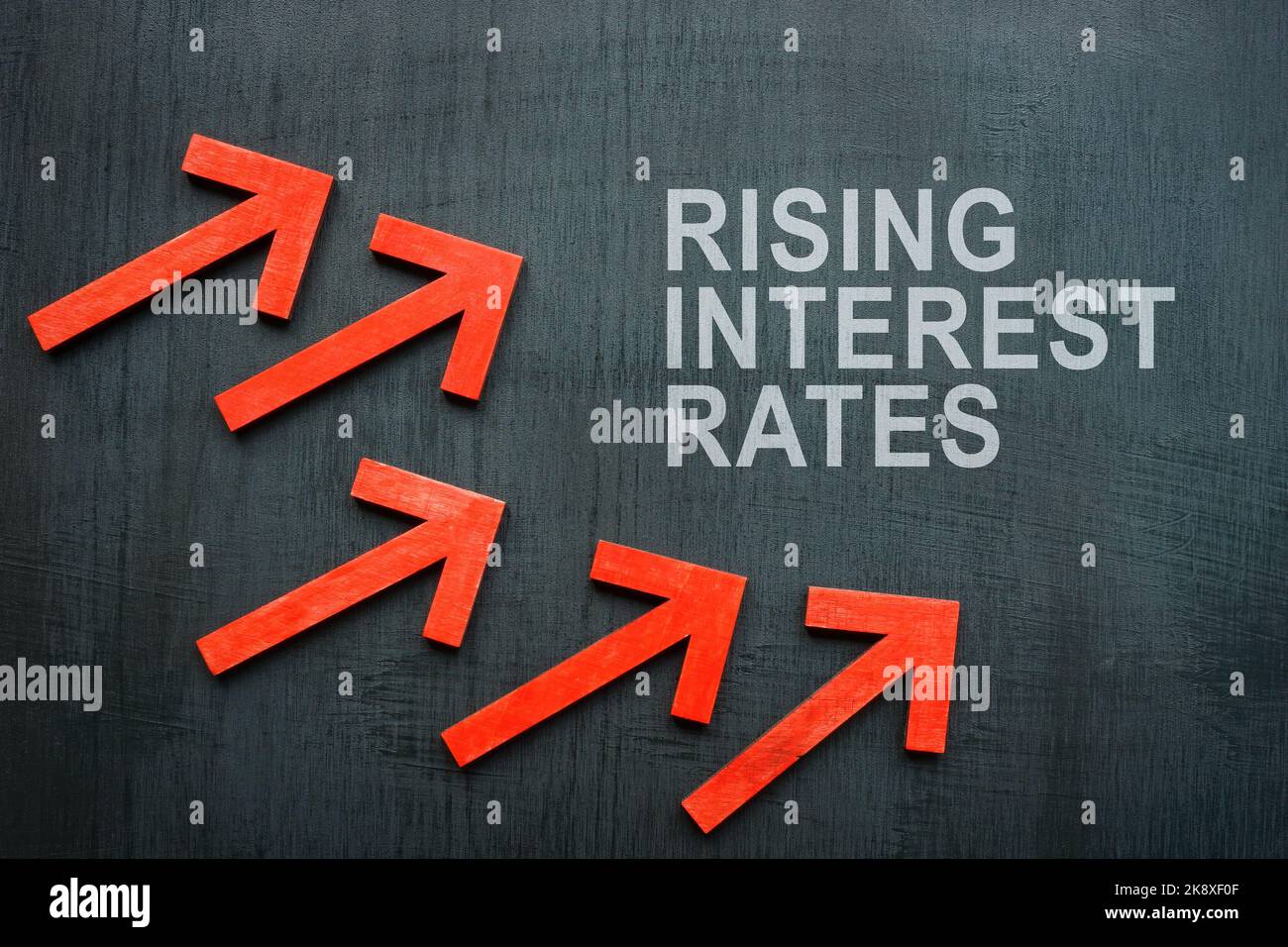 Inscription rising interest rates and red arrows. Stock Photo