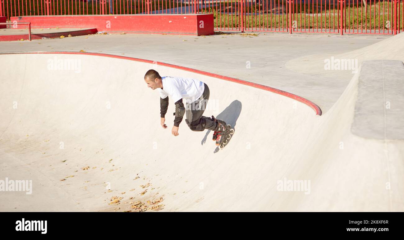 Energetic man on roller skates in motion at modern roller skate park