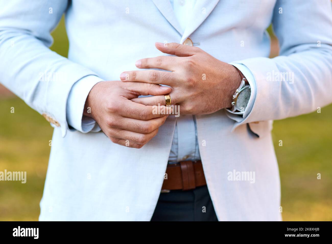 I feels good to be a married man. an unrecognizable bridegroom adjusting his ring on his wedding day. Stock Photo