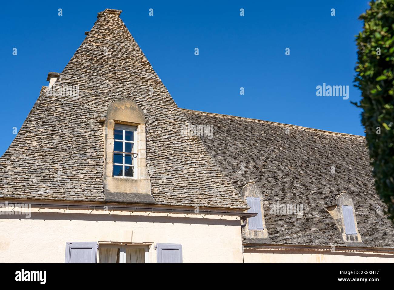 The Marqueyssac Chateau (Les Jardins de Marqueyssac) aged roof with hand cut stone tiles, clear blue sky, Dordogne France Stock Photo