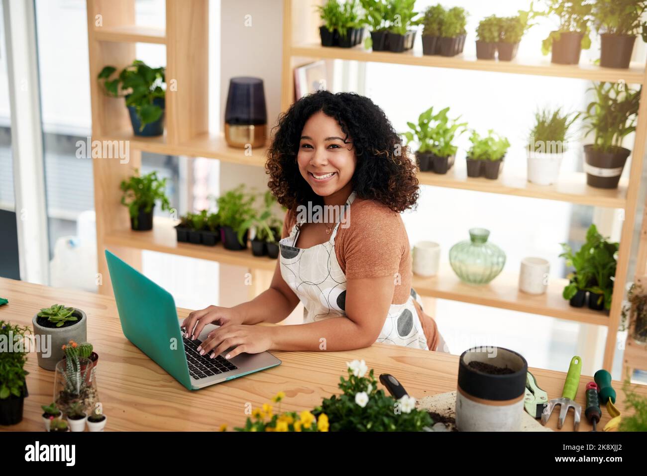 Im running my entire store online. High angle portrait of an attractive young female botanist working on a laptop in her florist. Stock Photo