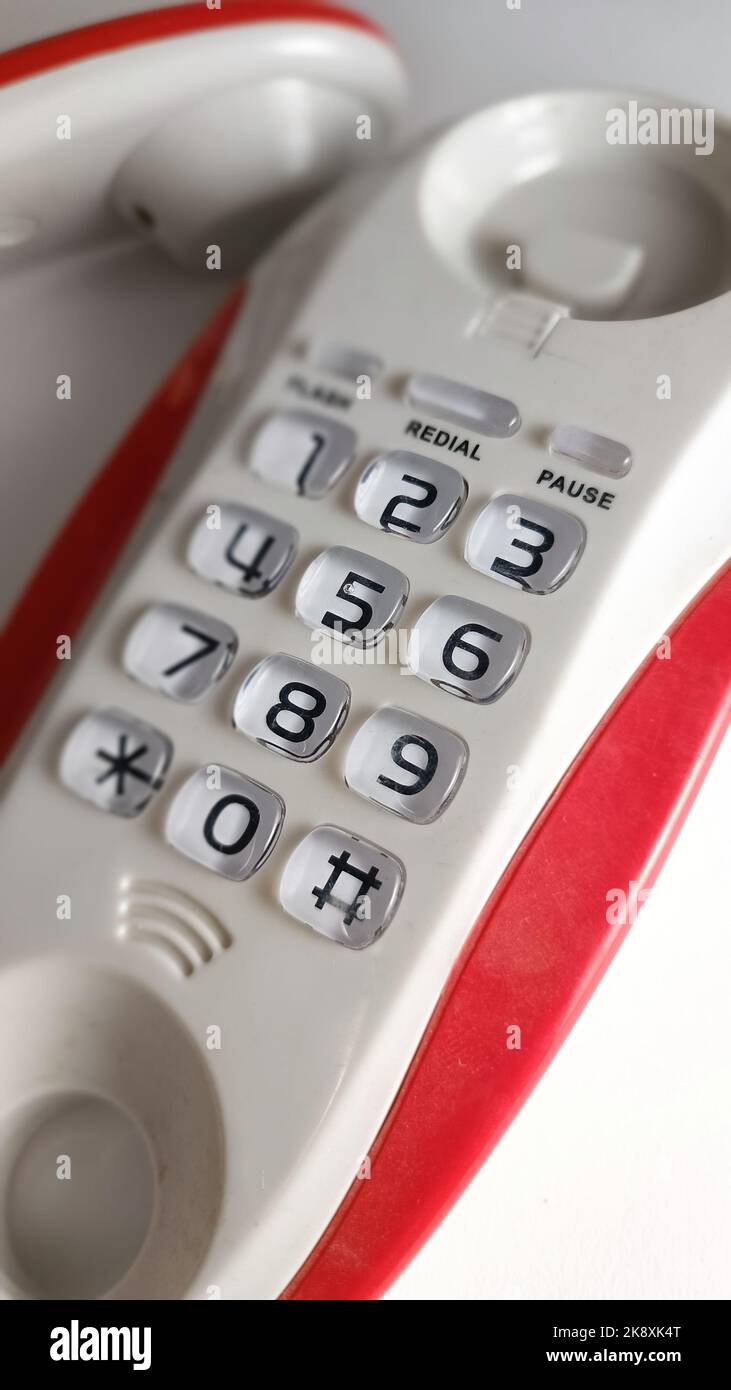 An old white and pink telephone with a keypad on a table Stock Photo ...