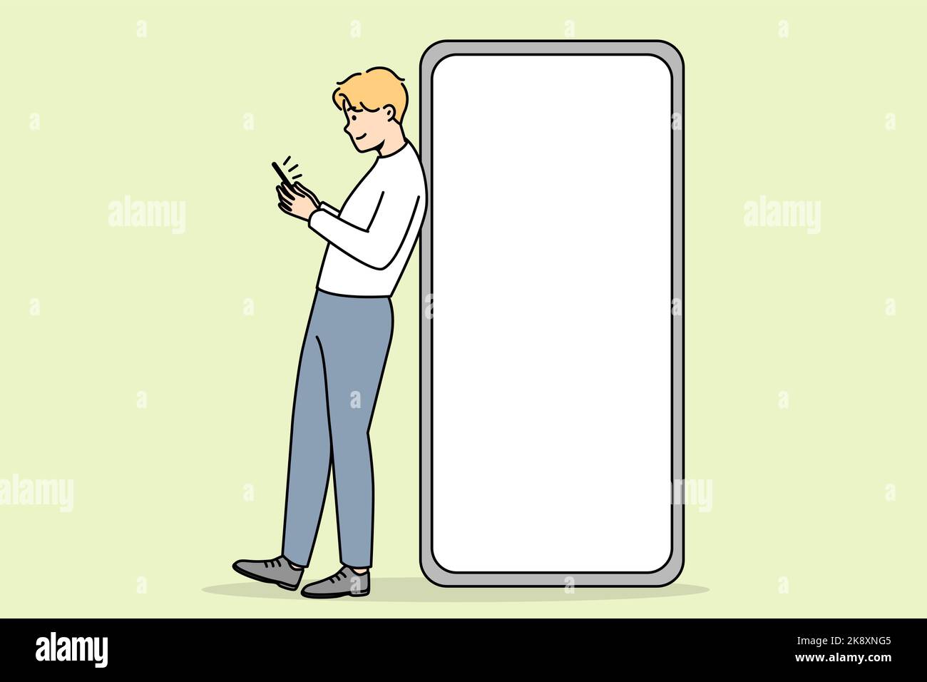 Young man standing near huge smartphone with mockup screen. Guy pose