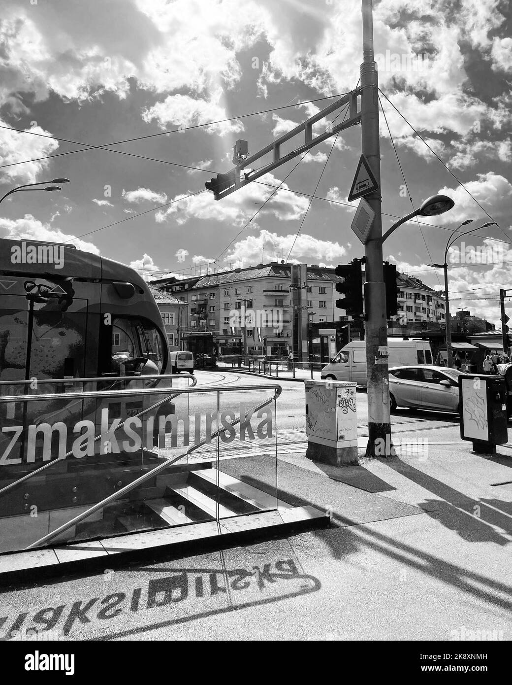 A vertical grayscale of busy highways and buildings under the cloudy