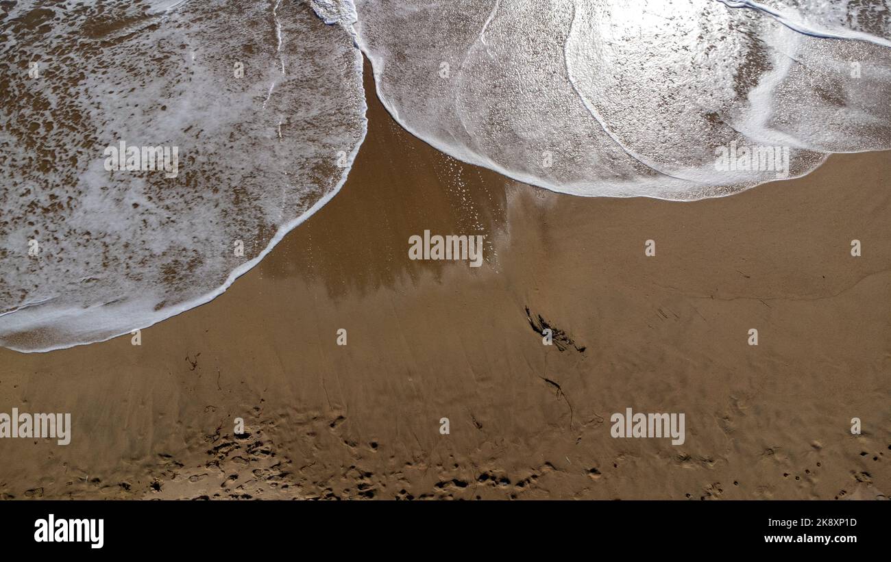 An aerial view of waves hitting the shore of a beach Stock Photo - Alamy