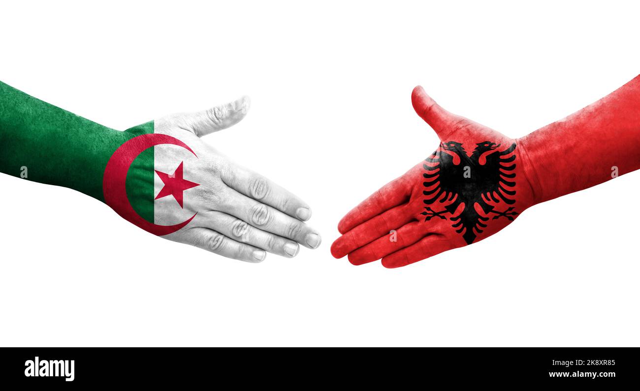 Handshake between Albania and Algeria flags painted on hands, isolated transparent image. Stock Photo