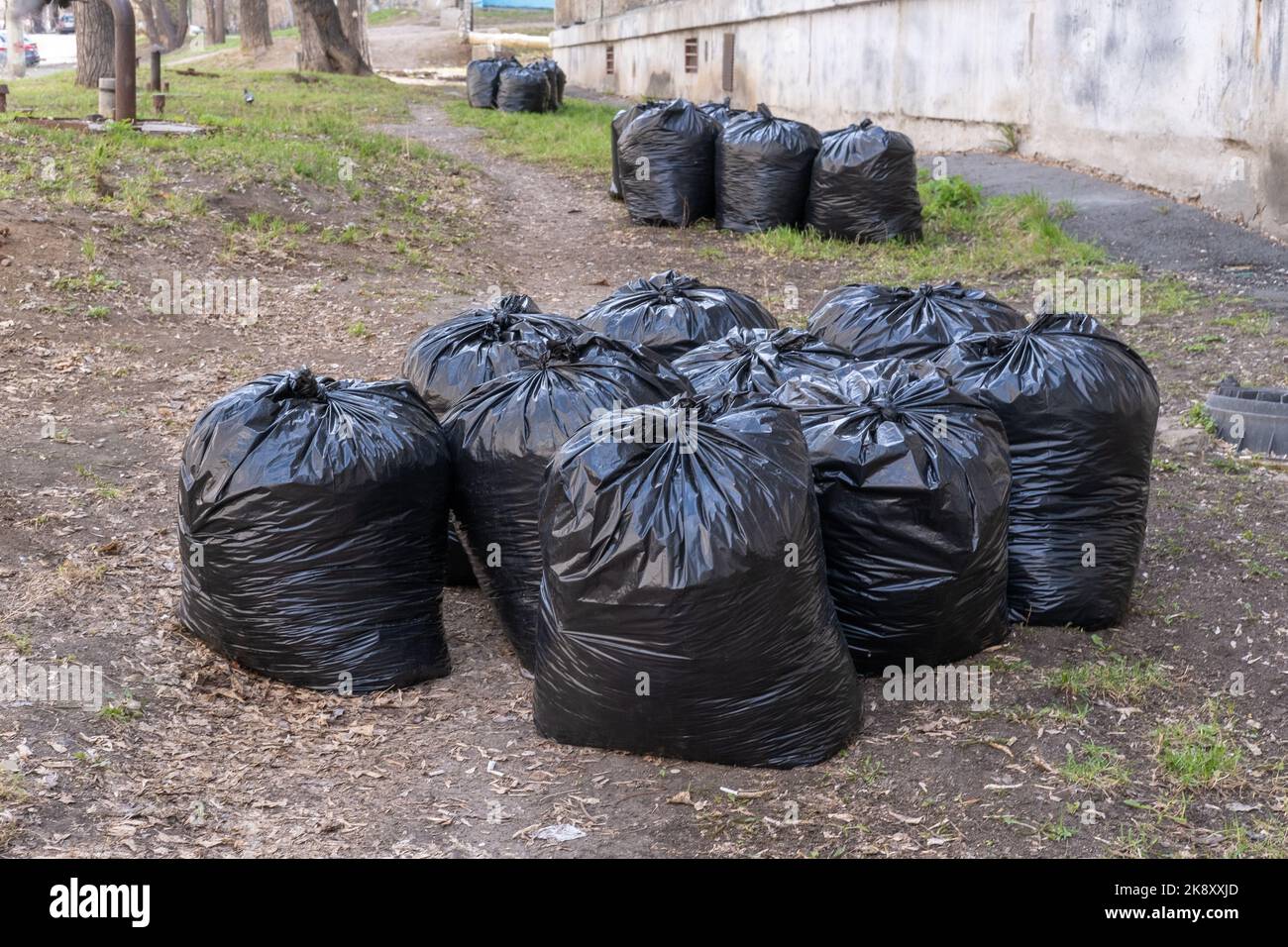 https://c8.alamy.com/comp/2K8XXJD/pile-of-plastic-garbage-bags-on-the-roadside-near-the-city-building-garbage-bags-on-the-street-black-waste-bags-the-concept-of-garbage-collection-2K8XXJD.jpg