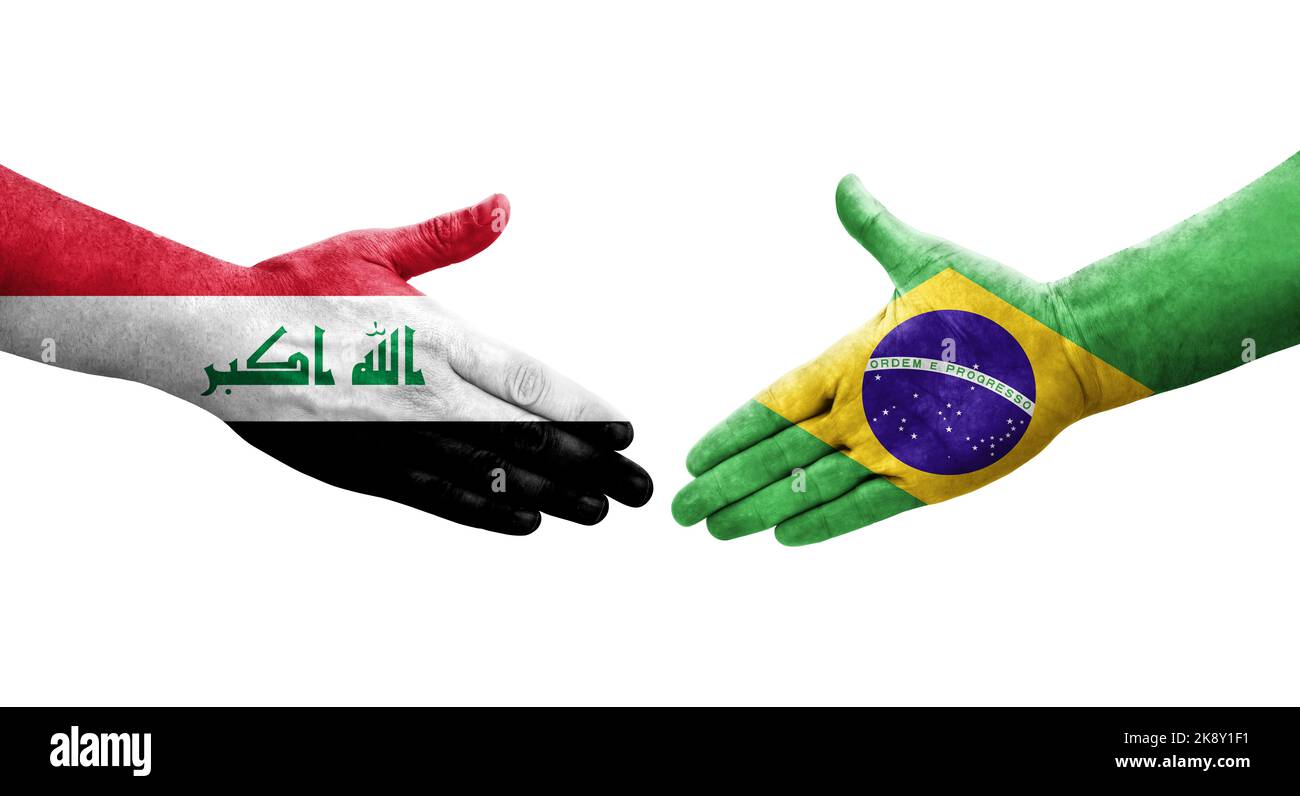 Handshake between Brazil and Iraq flags painted on hands, isolated transparent image. Stock Photo