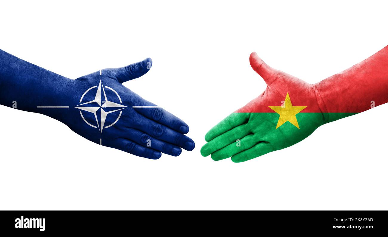 Handshake between Burkina Faso and Nato flags painted on hands, isolated transparent image. Stock Photo