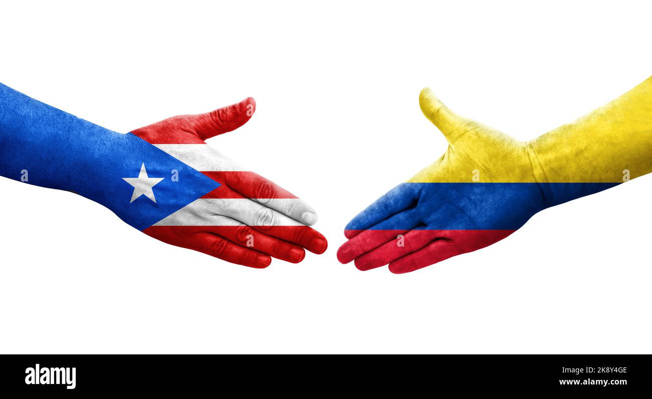 Handshake between Colombia and Puerto Rico flags painted on hands, isolated transparent image. Stock Photo