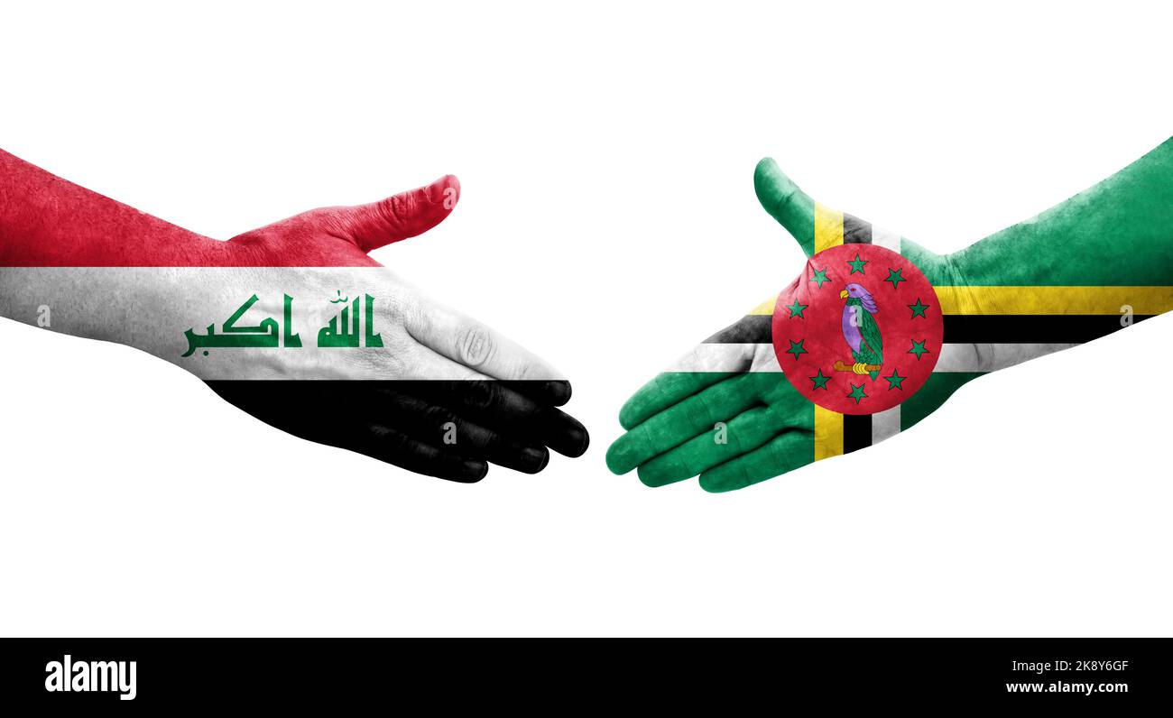 Handshake between Dominica and Iraq flags painted on hands, isolated transparent image. Stock Photo