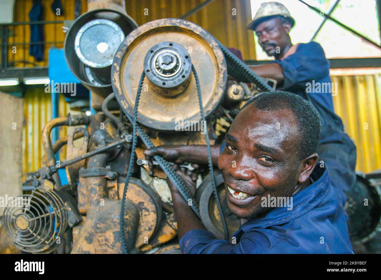 Ghana, Tarkwa. Men workers of Manganese mining repairing a motor in the