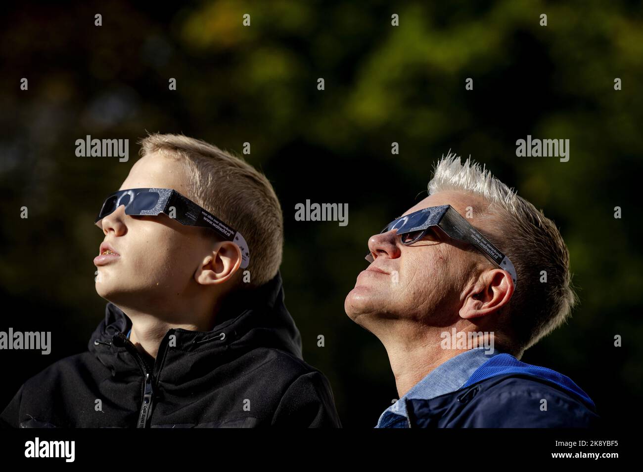 2022-10-25 11:51:51 UTRECHT - Visitors to the Sonnenborgh museum view a partial solar eclipse with eclipse glasses. The sun is partly hidden behind the moon, making it seem as if a bite is taken from the sun. ANP ROBIN VAN LONKHUIJSEN netherlands out - belgium out Stock Photo