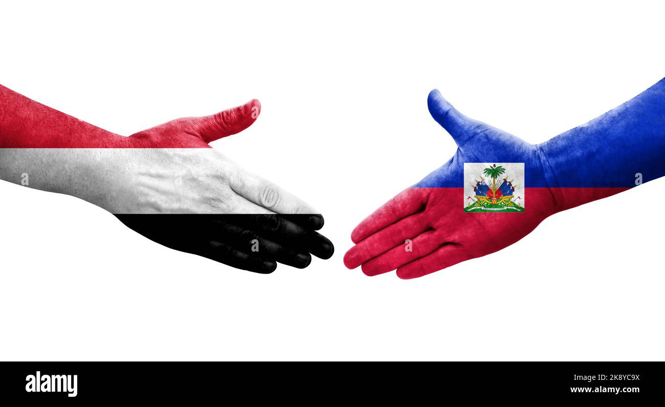 Handshake between Haiti and Yemen flags painted on hands, isolated transparent image. Stock Photo