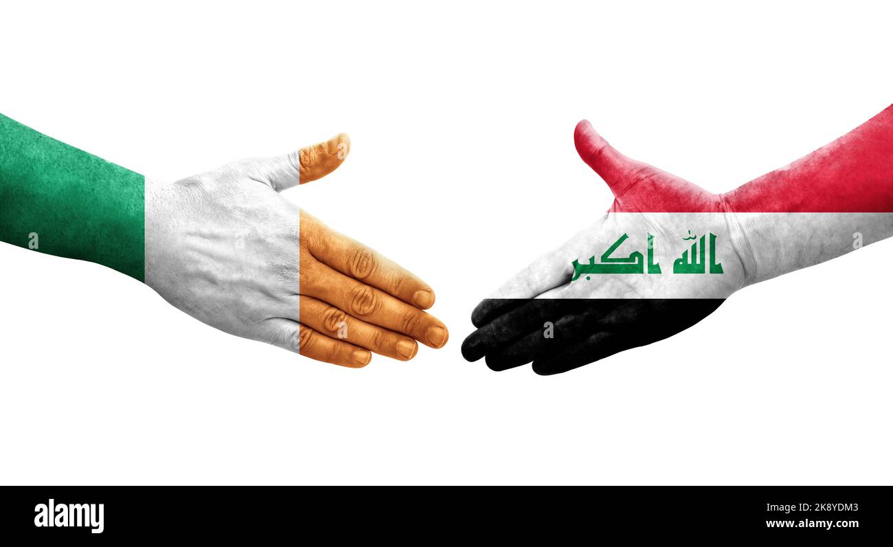 Handshake between Iraq and Ireland flags painted on hands, isolated transparent image. Stock Photo