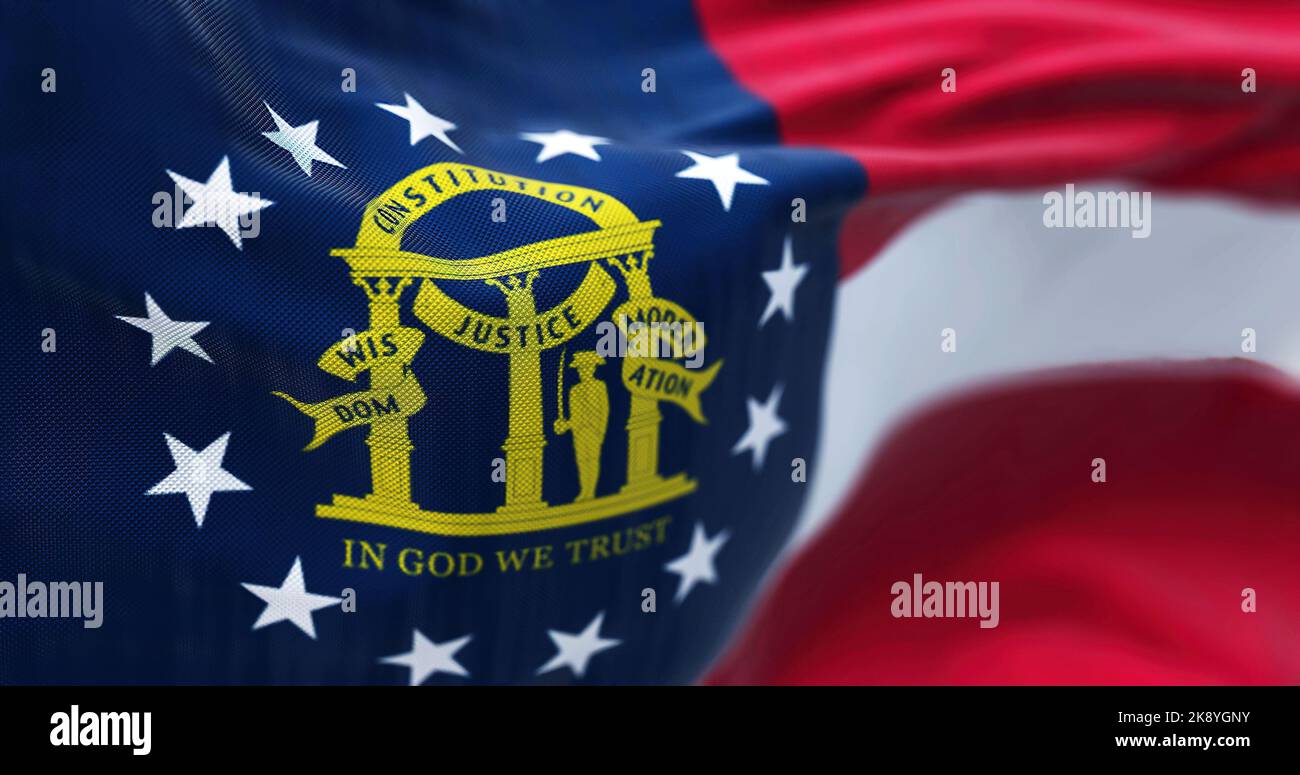 Close-up view of the Georgia state flag waving in the wind. Georgia is a federated state of the United States of America. Fabric textured background. Stock Photo