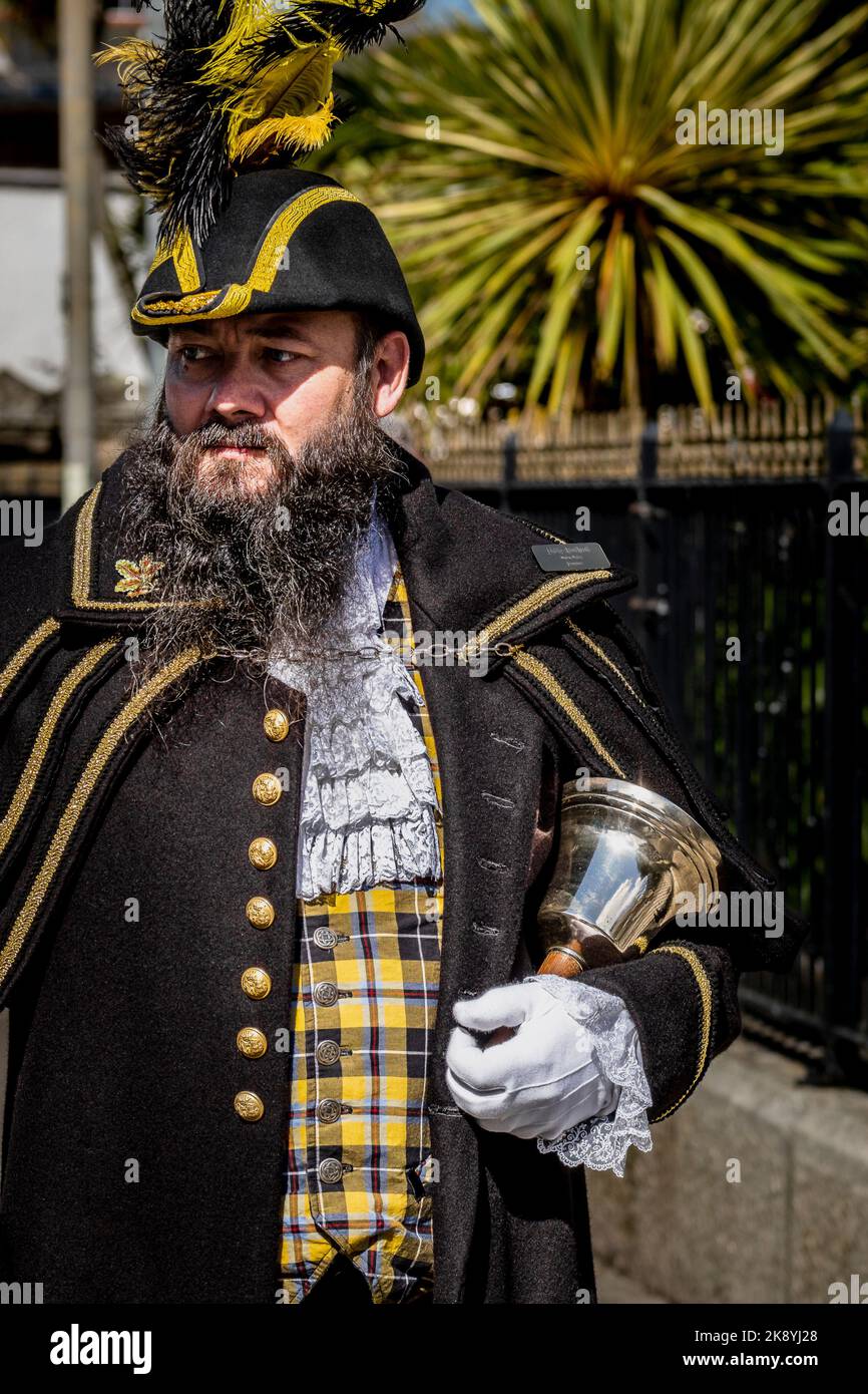 Philip Northcott the official Penzance Pensans Town Crier in full regalia and carrying his handbell in Cornwall in the UK. Stock Photo