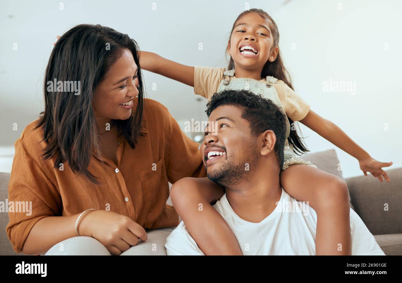 Happy family, love and relax on a sofa in a living room, laughing and playing in their home together. Love, smile and happy girl having fun with Stock Photo