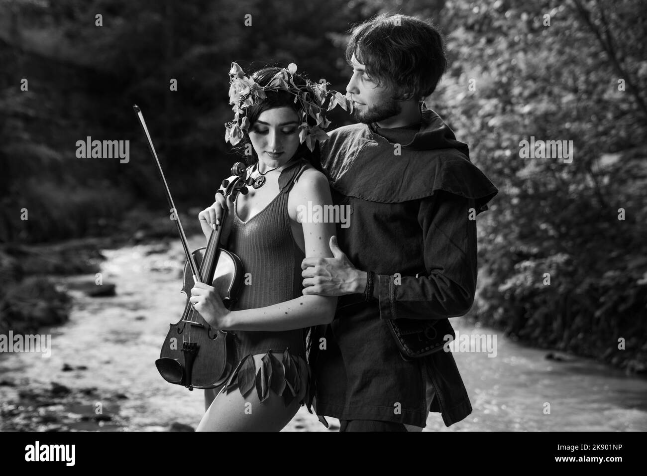 A closeup shot of a Romanian boy hugging a girl with a violin Stock Photo