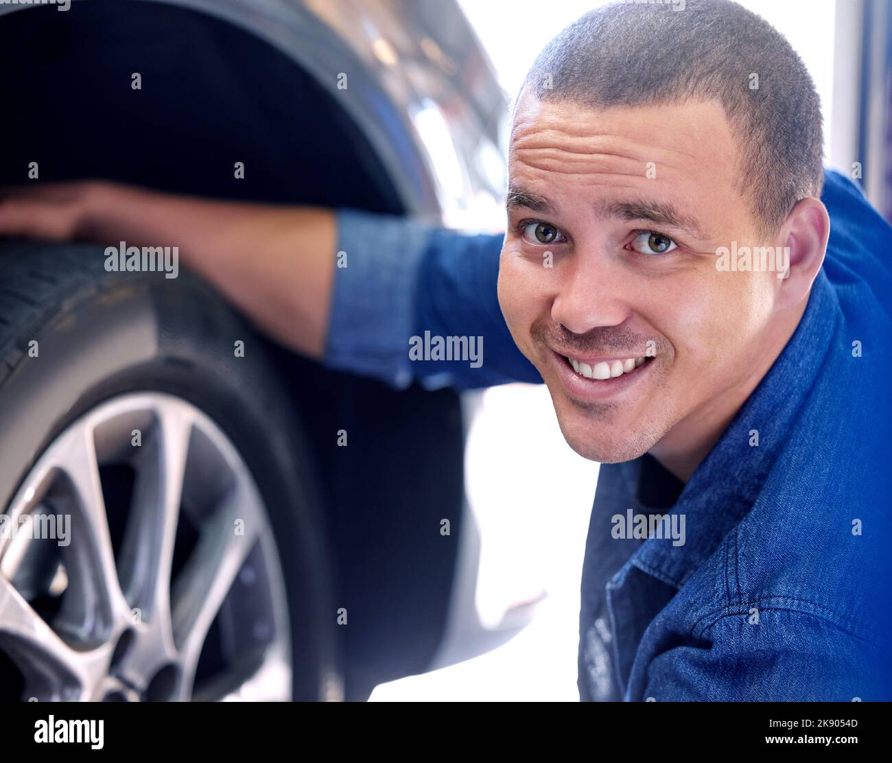 Mechanic, tire change and happy man car service assistant in automobile