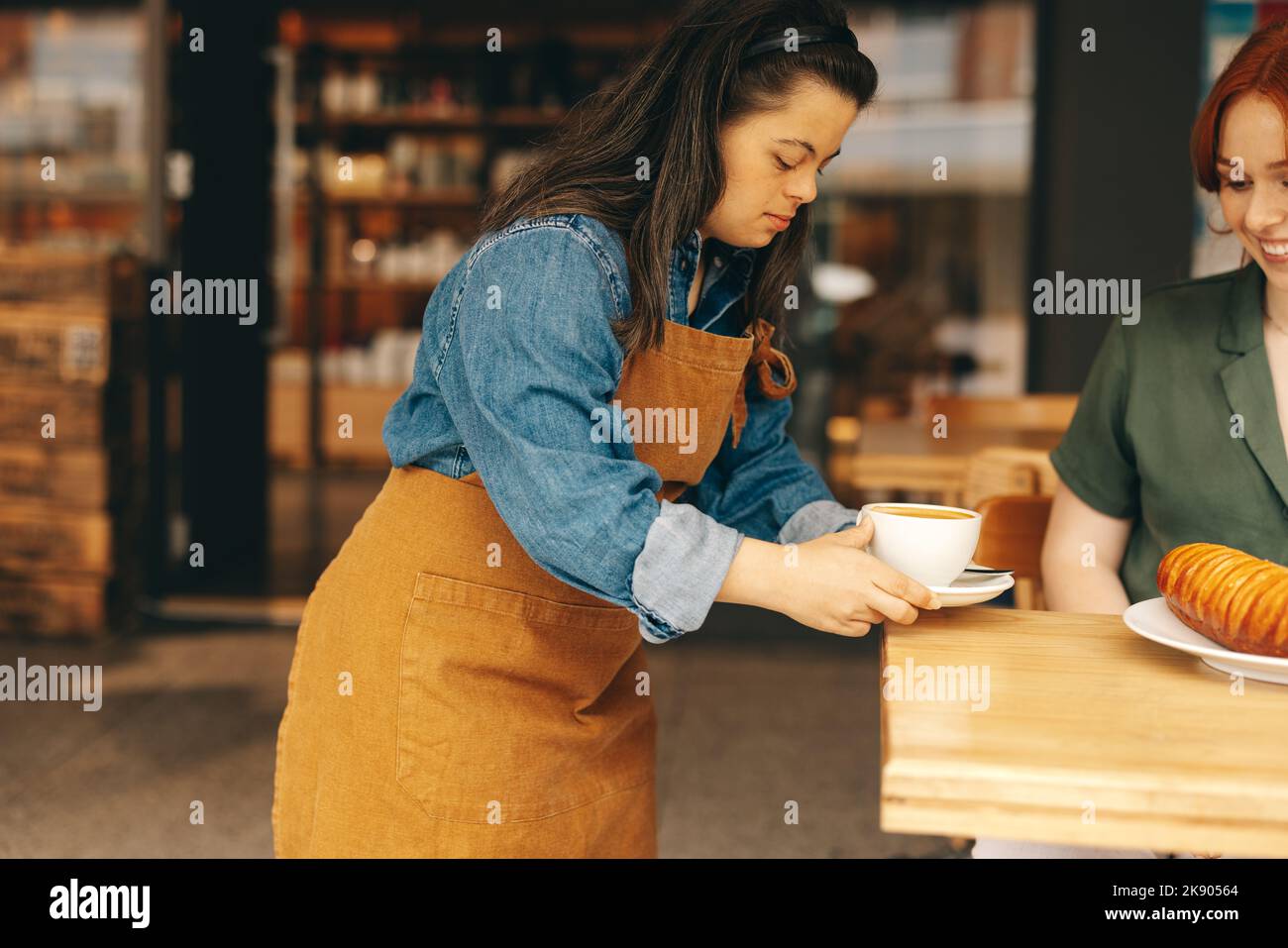 Professional waitress with Down syndrome serving a customer a sandwich