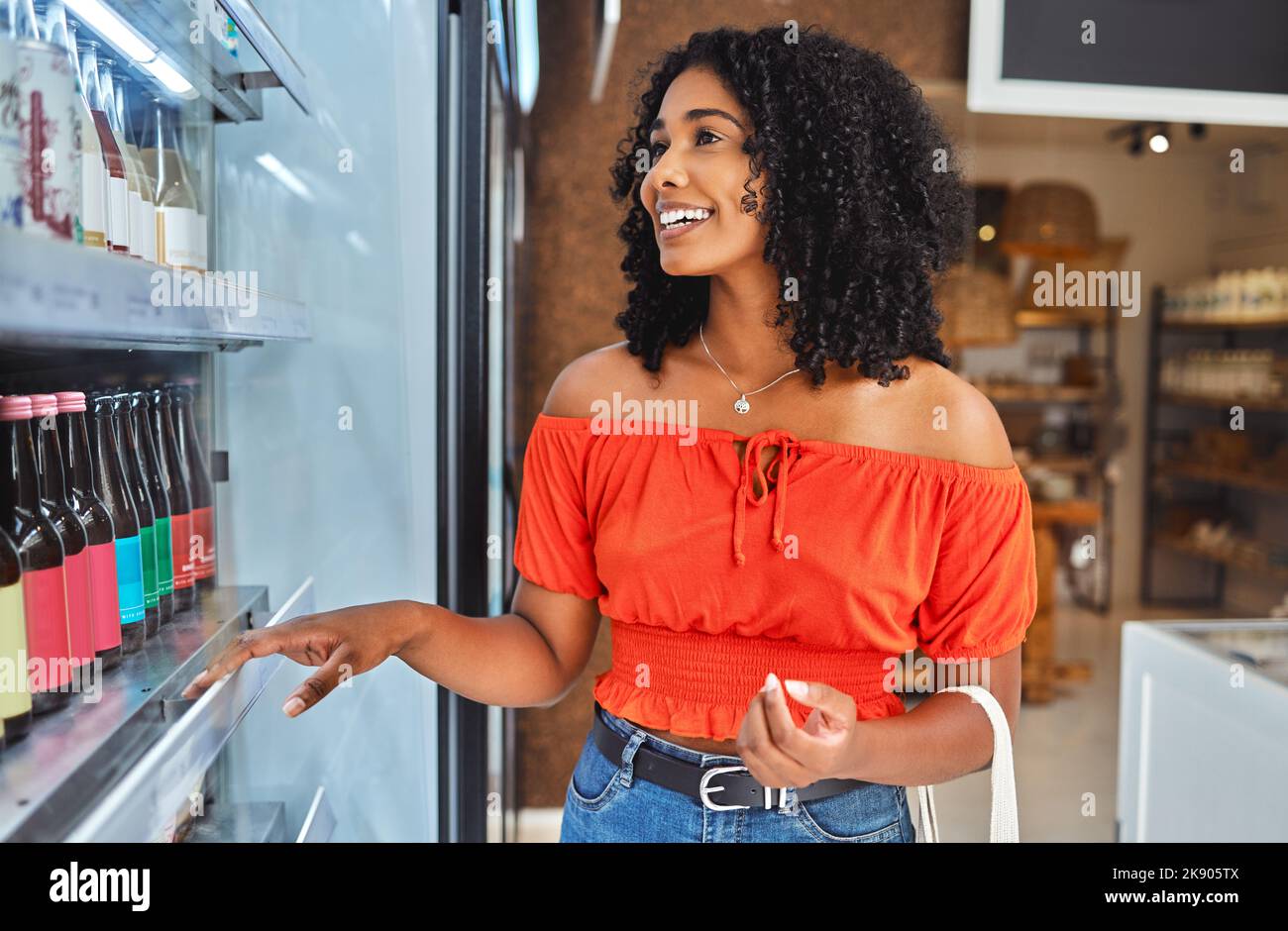 Happy, grocery shopping and woman in a supermarket with drinks at a retail store in Sao Paulo. Happiness, smile and girl from Brazil buying a beverage Stock Photo