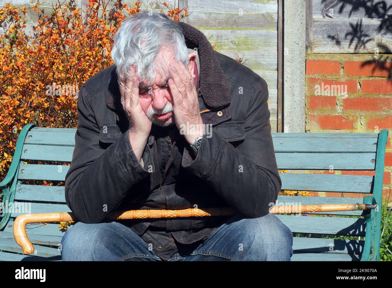 Old or senior man hands on head suffering anxiety or depression. Lonely man finding life difficult. Stock Photo