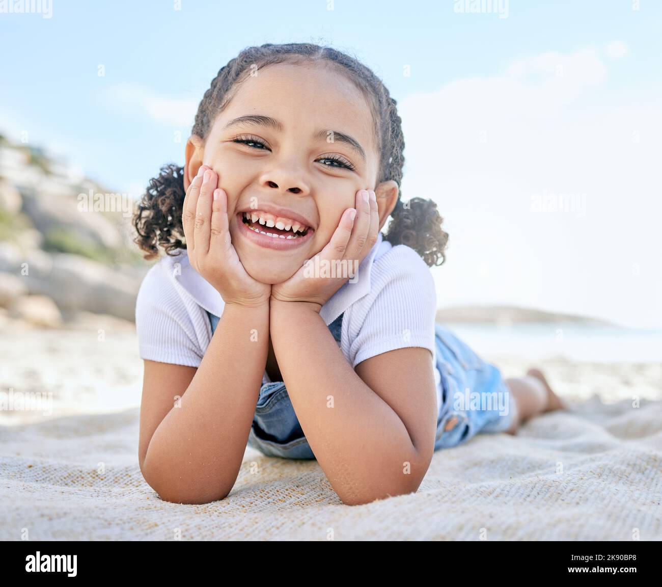 Child, smile and happiness on beach vacation picnic in summer with a