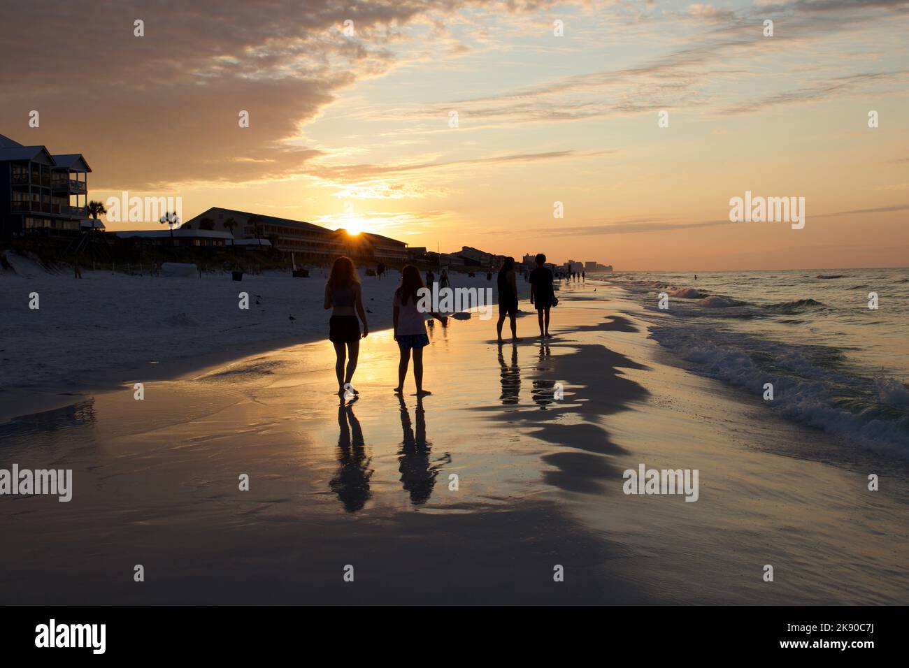 A beautiful shot of friends walking near the beach on a sunset Stock ...