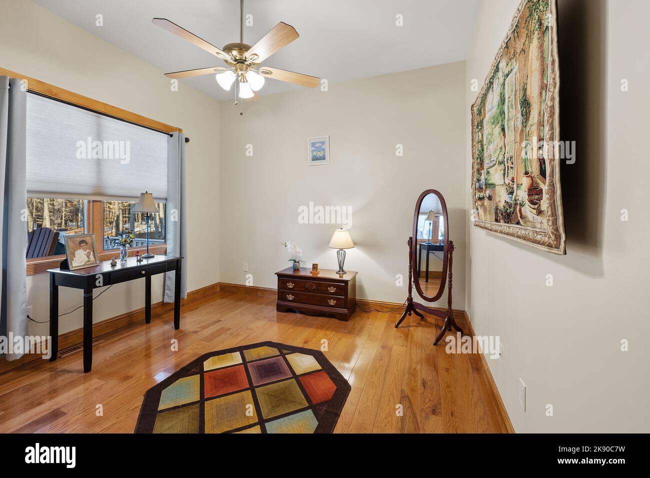 A rustic room interior with a ceiling fan, wooden floors, a mirror, and