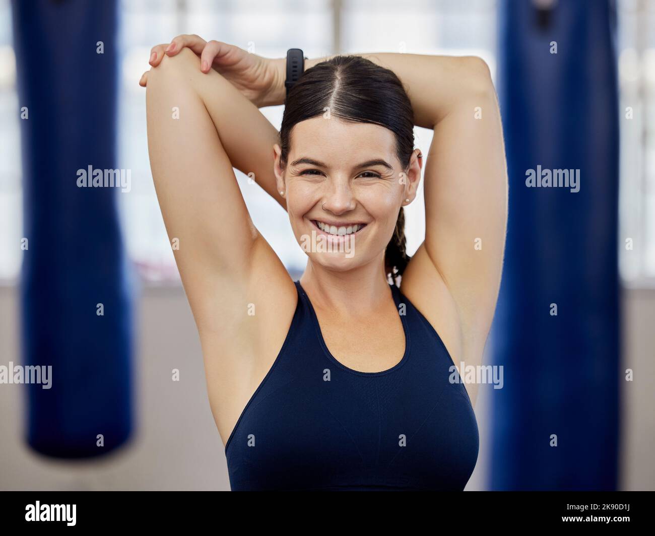 Gym, fitness and woman stretching before exercise training at wellness studio, happy and relax body warm up. Workout, portrait and face of lady arm Stock Photo