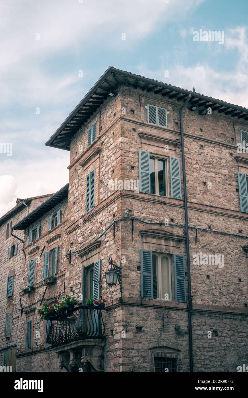 A vertical low-angle of an abandoned building with cloudy sky ...