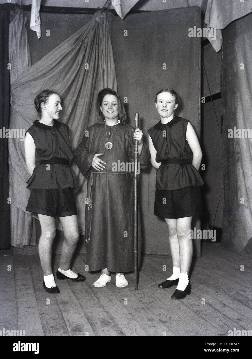 1955, historical, February, three teenagers in costumes posing on stage for their photo, they are appearing in the pantomine, Robin Hood, Leeds, England, UK. The monk Friar Tuck with his two merry (wo) men. Stock Photo