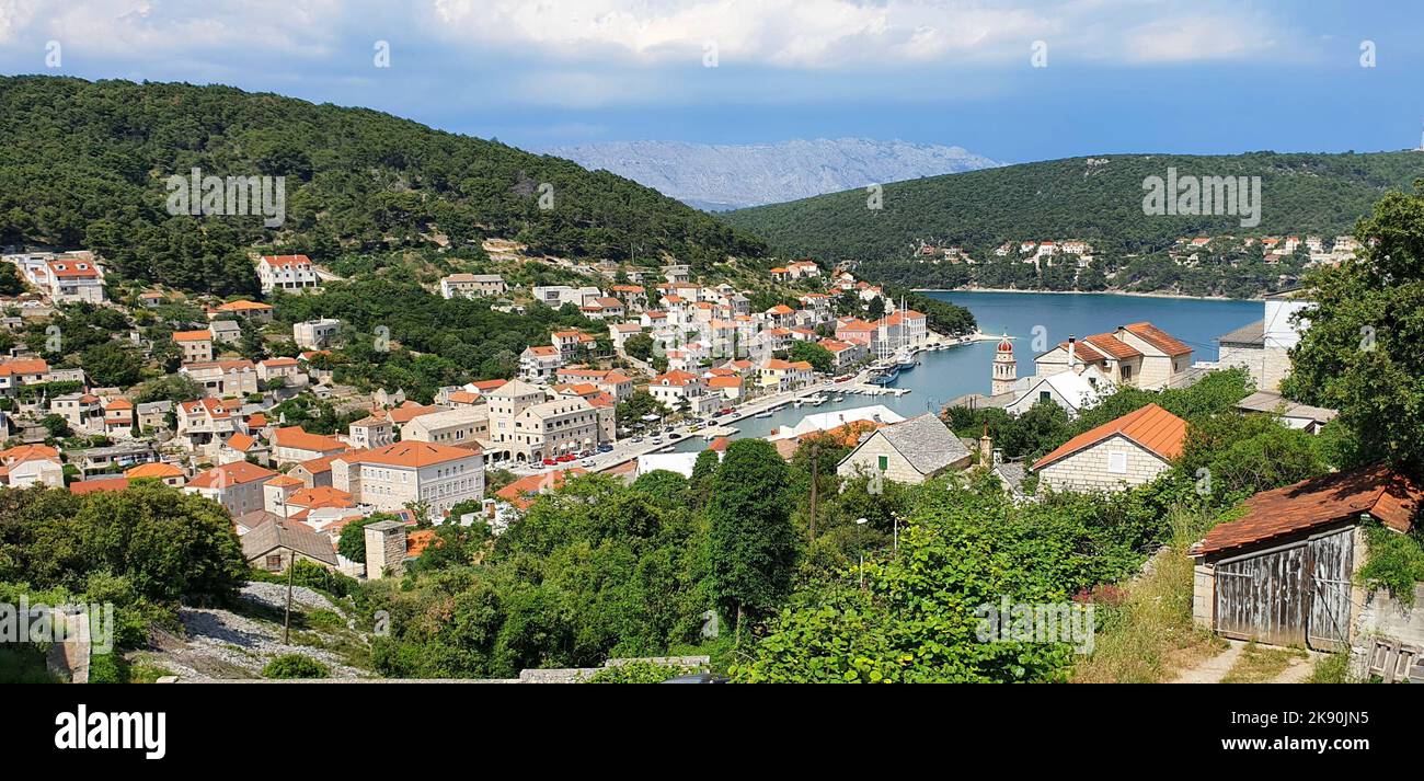A scenic view of seaside buildings and houses between green hills Stock ...