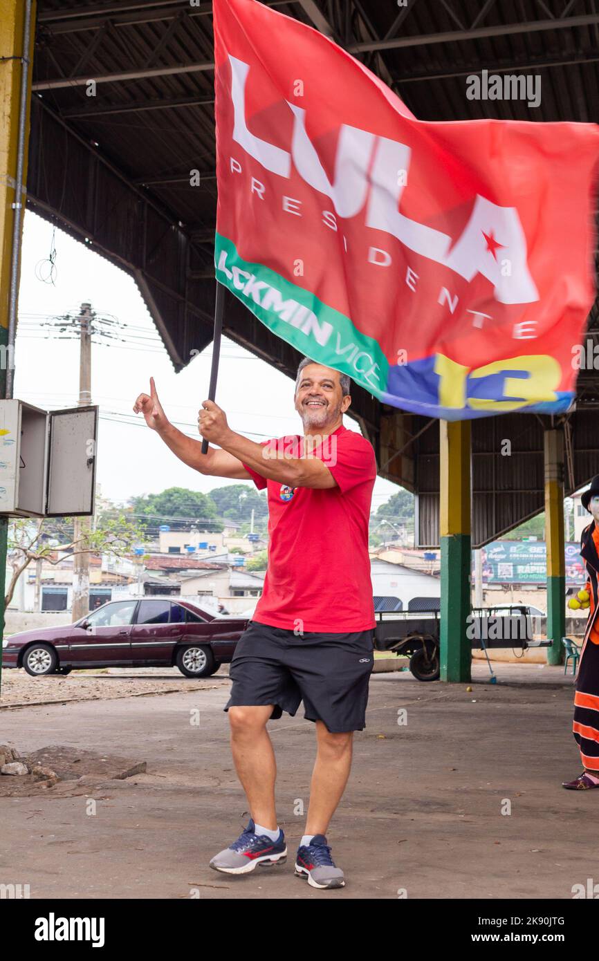 Goiânia, Goias, Brazil – October 21, 2022: A man walking holding a Lula flag. Image made in an act to ask for votes for Lula. Stock Photo