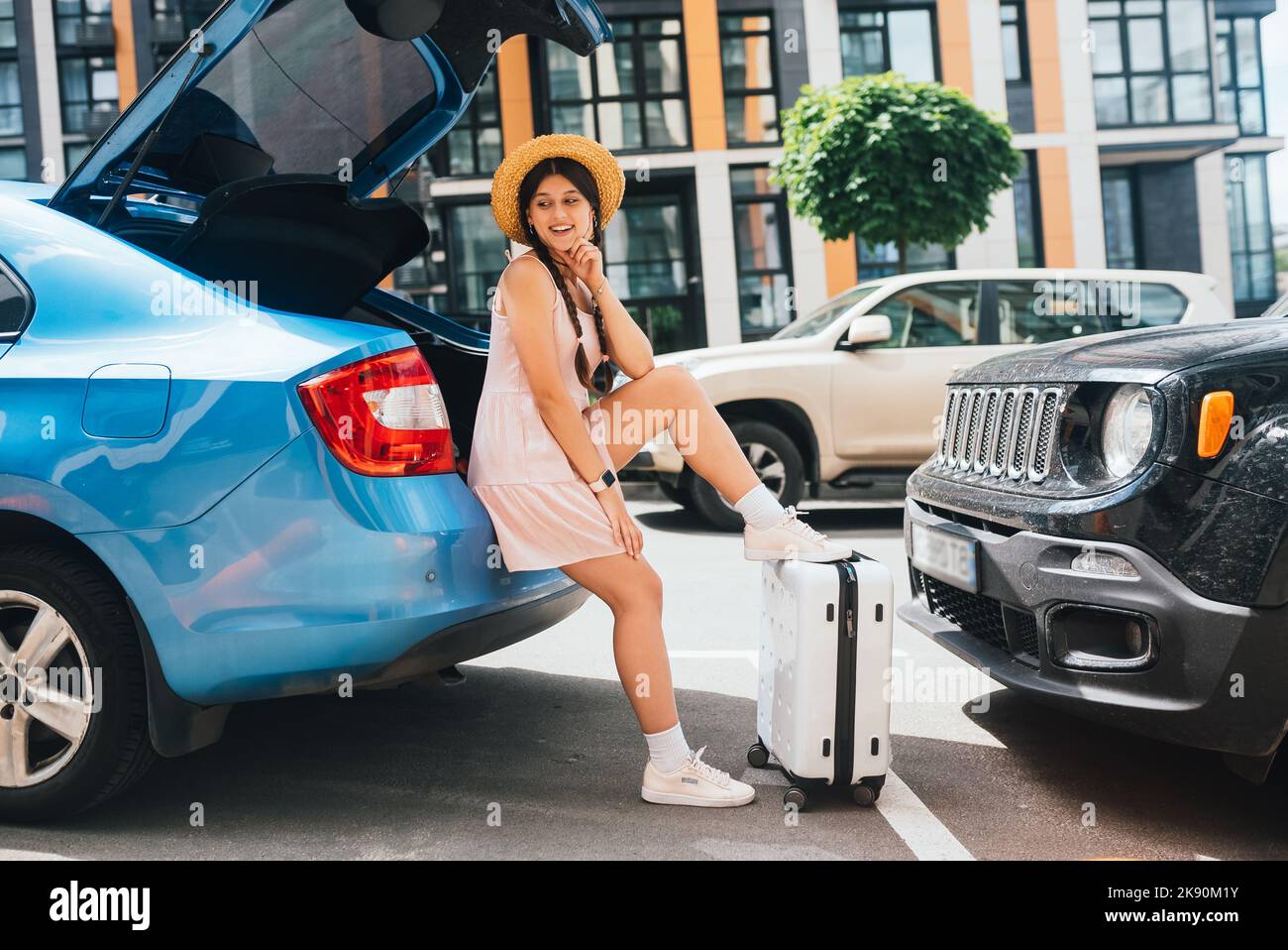 Woman packing her suitcase into luggage boot of the car Stock Photo - Alamy