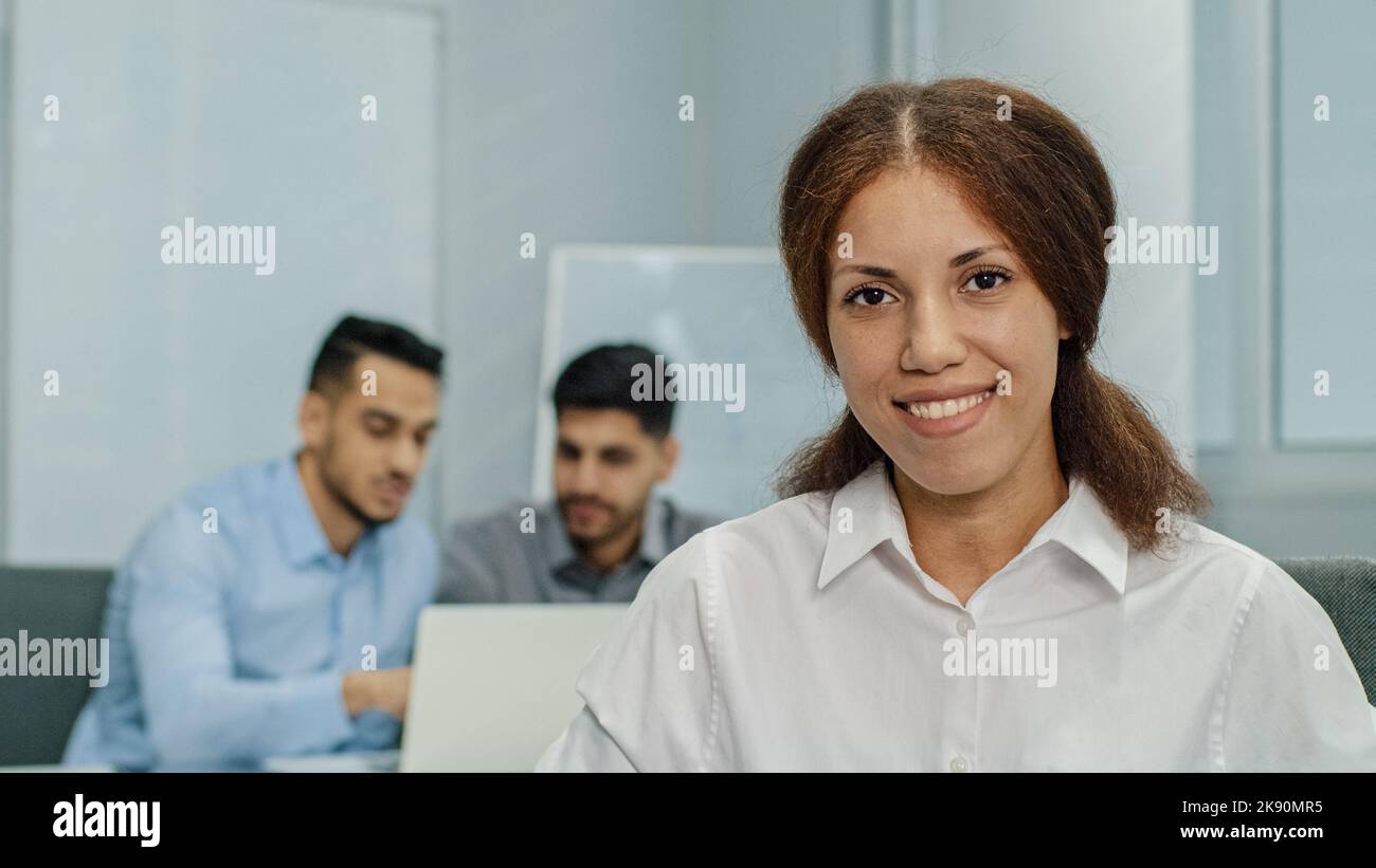 Smiling female leader manager coach speaker looking at camera. Friendly businesswoman greeting or welcoming new worker in modern business office with Stock Photo