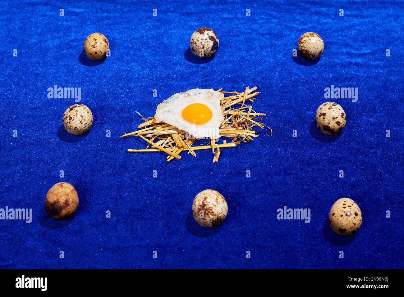 Food pop art photography. Composition with quail and chicken eggs on bright blue tablecloth. Retro style, colorful minimalism, art, creativity Stock Photo