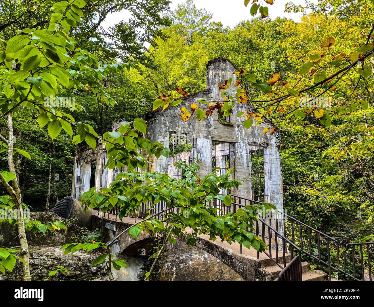 A view of Carbide Willson Ruins and a bridge in a lush green forest, Gatineau Park, Chelsea, Quebec, Canada Stock Photo