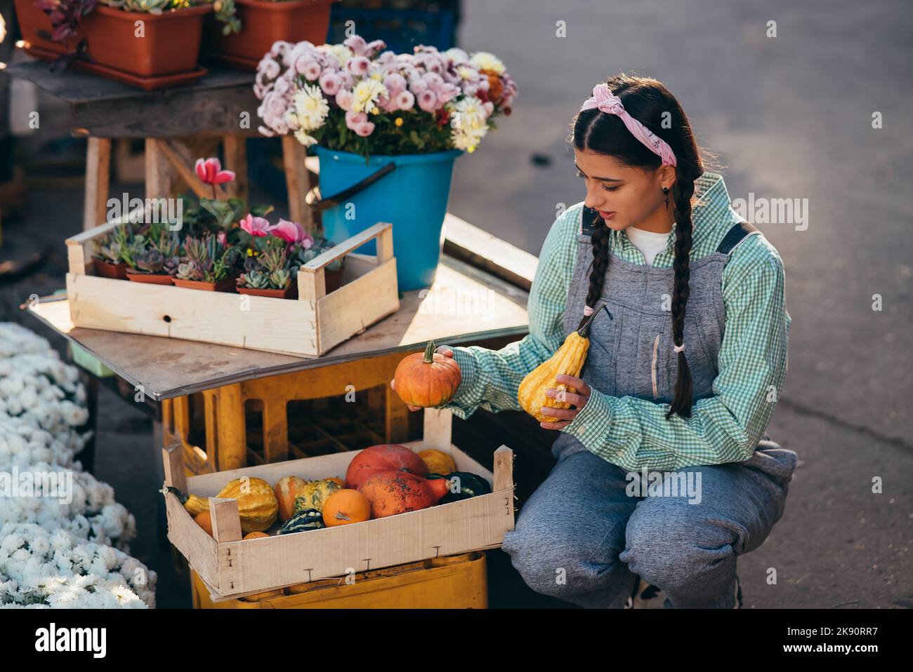 Farmer woman decor a wooden box with small pumpkins Stock Photo