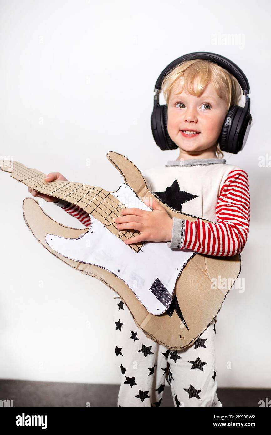 Learning to play guitar. little funny girl with DIY guitar. musical