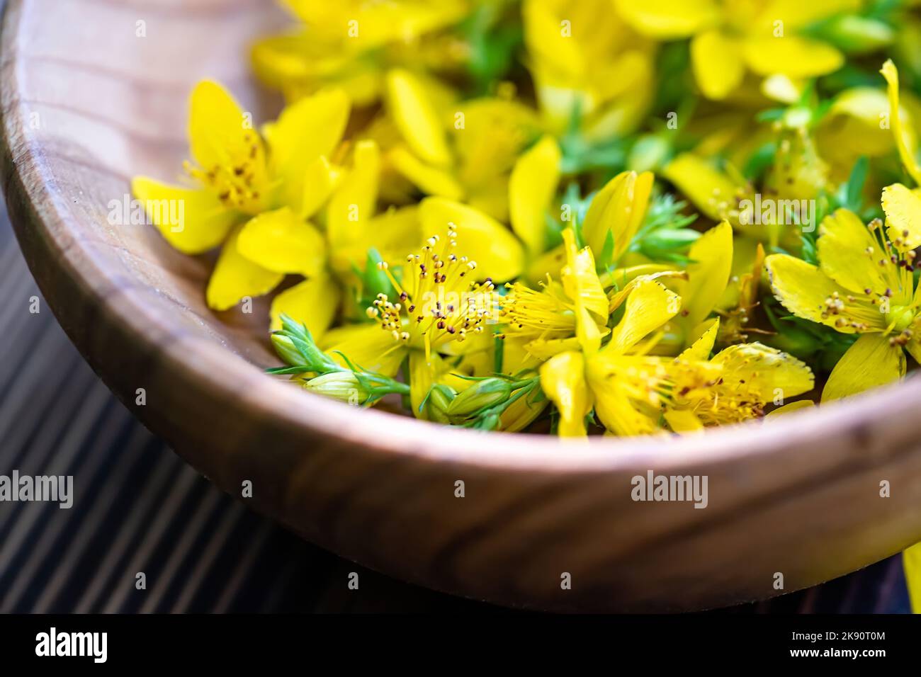 St. John's wort. Hypericum plants yellow flower used in alternative medicine in a wooden plate on a vintage table. Medicinal herbs Hypericum for Stock Photo