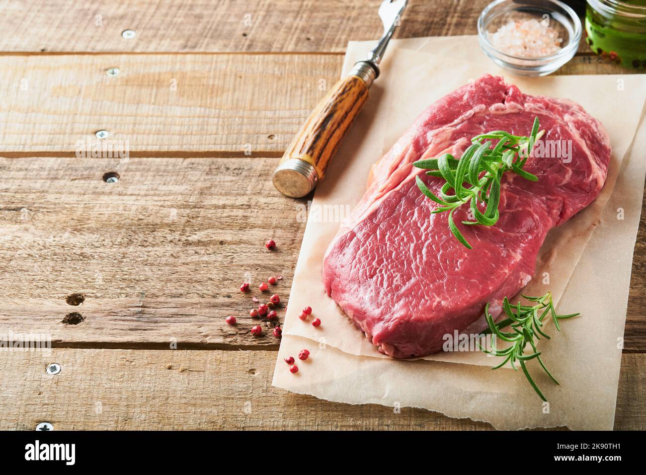 Raw beef steak. Fresh beef rib eye steak with fork rosemary, salt and ...