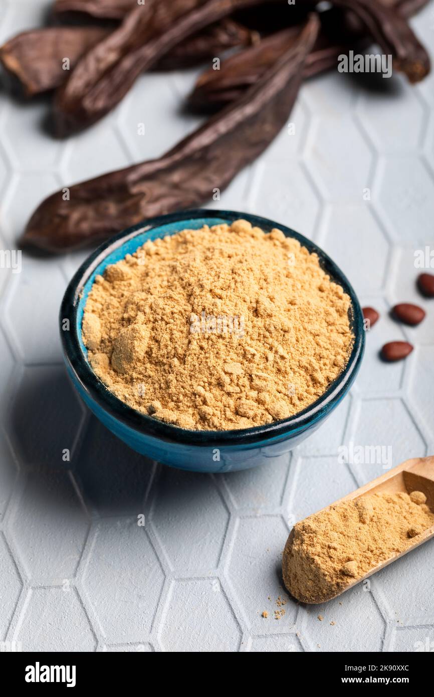 Carob pods and carob powder over a blue background Stock Photo - Alamy