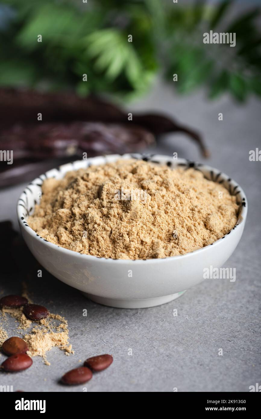 Carob pods and carob powder over a stone background Stock Photo Alamy