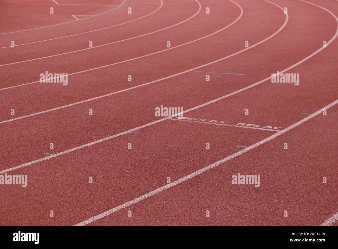 White lines forming lanes of an athletics track made of red rubber Stock Photo