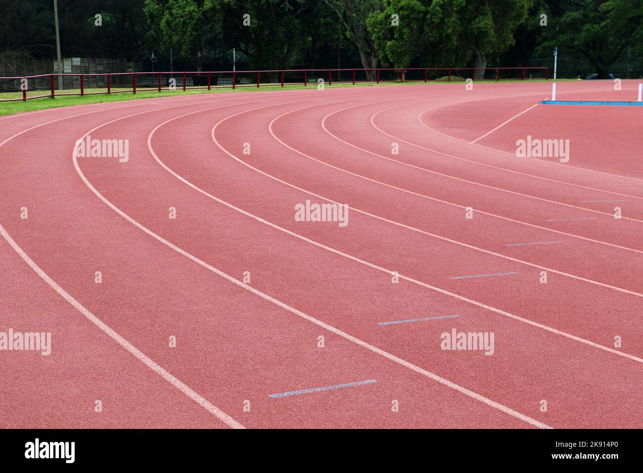 White lines forming lanes of an athletics track made of red rubber