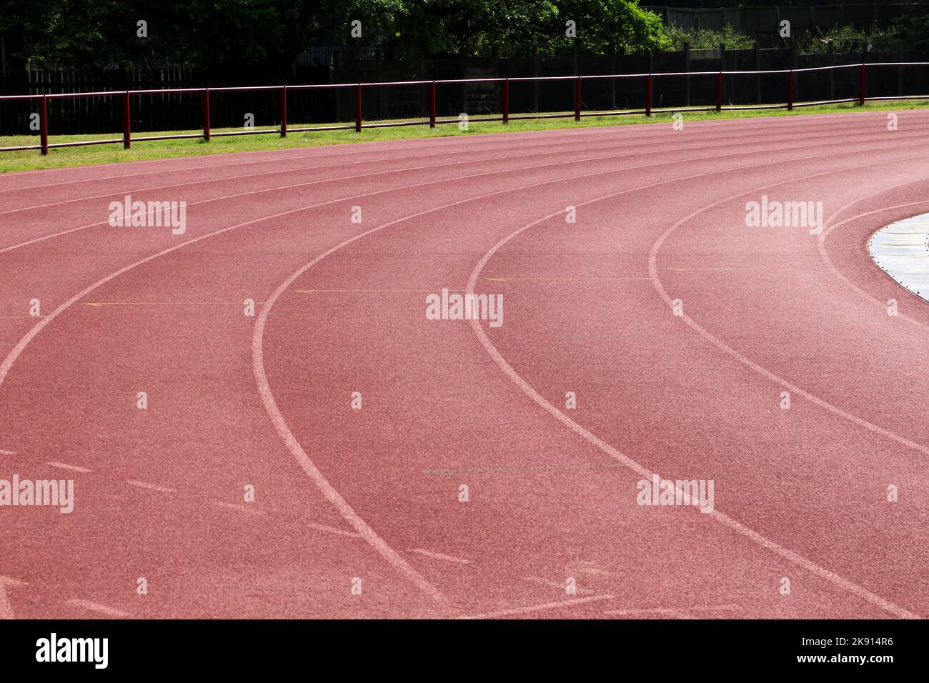 White lines forming lanes of an athletics track made of red rubber Stock Photo