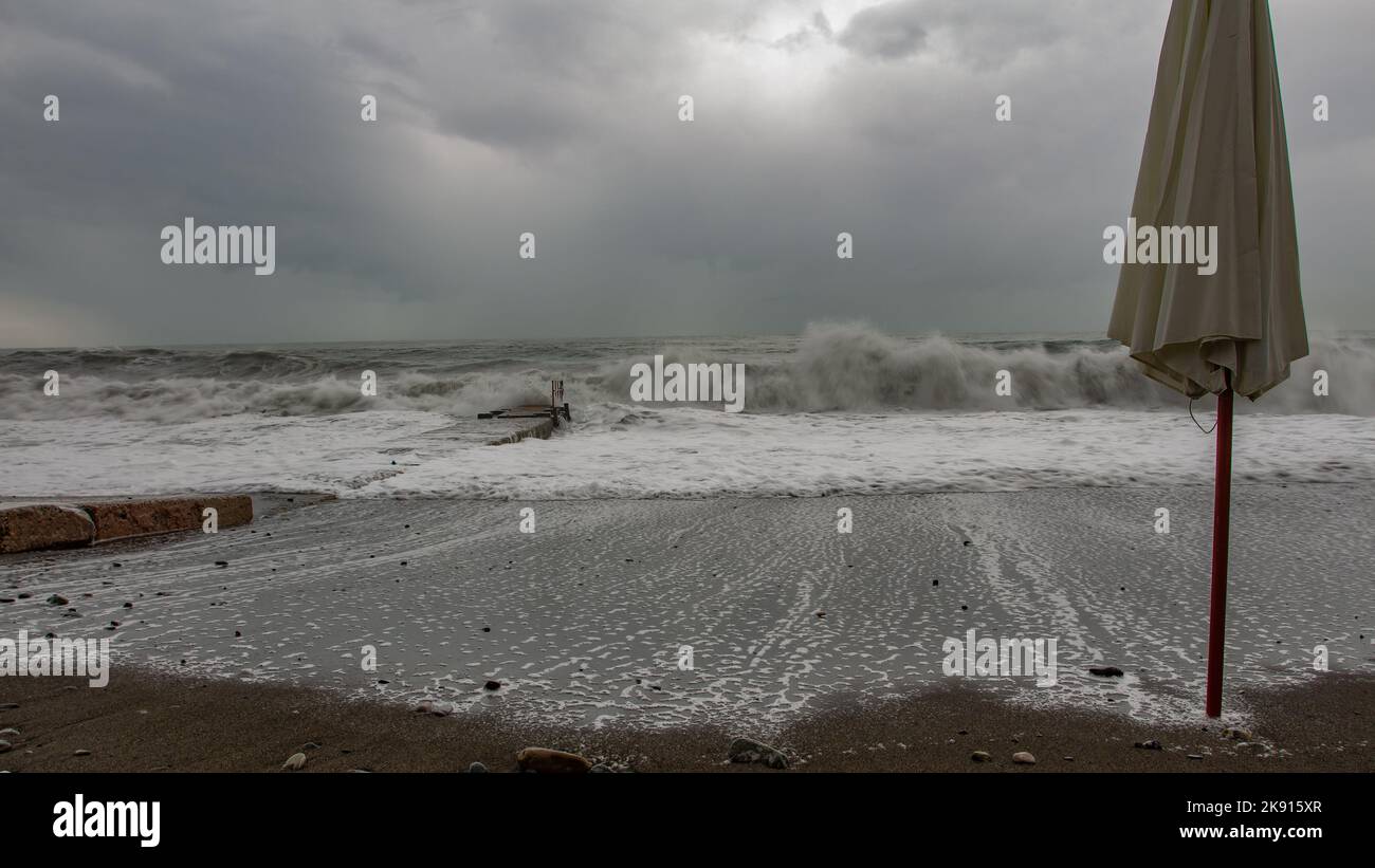 Stormy weather and a concrete structure coastline barrier with the ocean beyond and islands in the background. Stock Photo